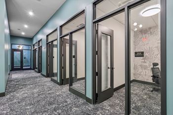 A hallway with glass doors and a carpeted floor. at LiveWell Apartments, Pennsylvania, 15222